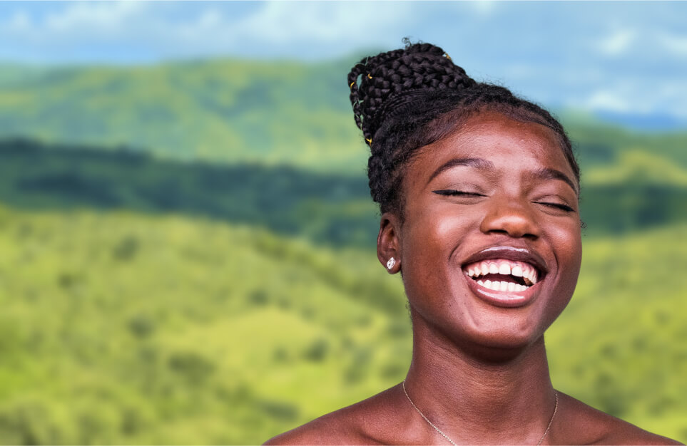 alt=’Portrait of a laughing woman against a backdrop of lush, rolling hills'